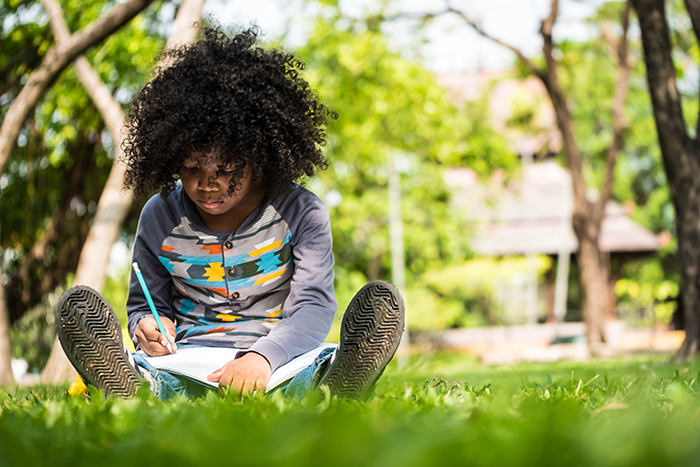 child writing outdoors
